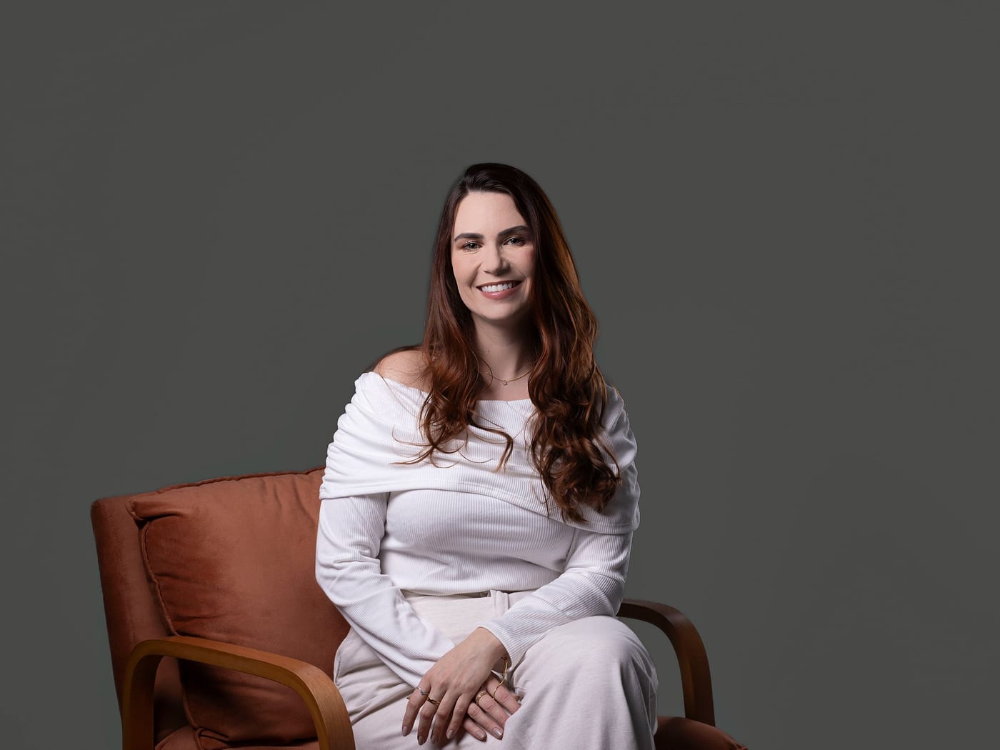 Dra. Janice Silveira sentada em uma poltrona, em retrato de estúdio